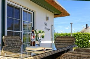 einen Glastisch mit einer Flasche Wein und ein Buch in der Unterkunft Villa Sorgenfrei - a65549 in Zinnowitz