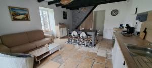 a kitchen and living room with a couch and a table at La tanière de Lise in Puyravault