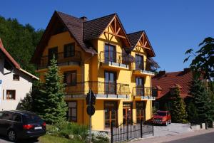 カルパチにあるDARIA pokoje gościnneの黒屋根の黄色い建物