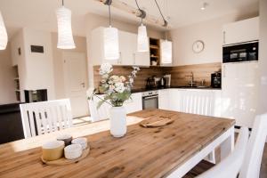 a kitchen with a wooden table with a vase of flowers at Ferienhaus Meeresschatz in Zingst