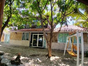 a house with a tree in front of it at Sharick Beach House in Tubará