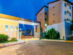 a house with a driveway in front of a building at Apê Confortável com Piscina I Wi-Fi e A/C in Imperatriz