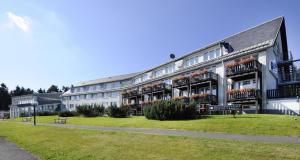 a large white building with flowers on the balconies at Ferienhaus Nr 1 Sporthotel Oberhof in Oberhof