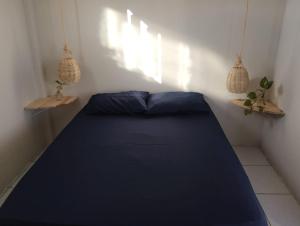 a bed in a room with two potted plants at La Belle Pipa in Pipa