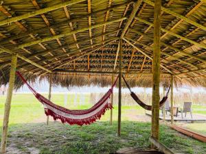 バヘイリーニャスにあるRedário nos Lençois Maranhenses - Canto de Atinsの藁小屋内のハンモック(テーブル、椅子付) +26枚の写真