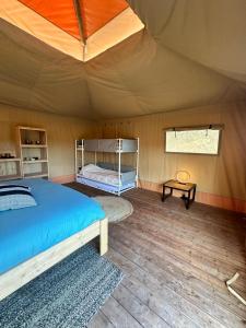 una camera da letto con un letto in una tenda di Back to Basic a Zwaanshoek