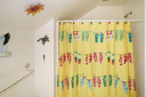 a shower curtain decorated with flip flops at Cockleshell Cottage - Pet friendly & Handicap Accessible! in Deep Hole +17 photos