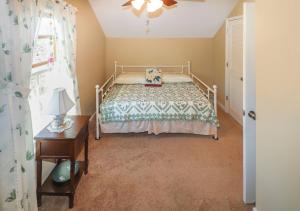 a bedroom with a bed and a table and a window at Cockleshell Cottage - Pet friendly & Handicap Accessible! in Deep Hole