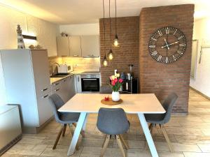 a kitchen with a table and a clock on a wall at Appartment 2015 in Tossens in Tossenserdeich