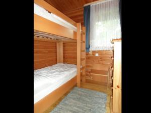Un dormitorio con dos literas y una ventana. en Ferienhaus Nr 17, Typ B, Feriendorf Jägerpark, Bayerischer Wald, en Prackenbach