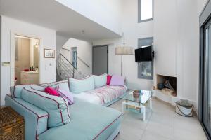 un soggiorno con divano blu e cuscini rosa di Luxury Villa Oceania Lindos with Private Infinity Pool a Líndos