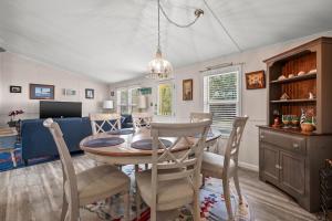 una sala da pranzo e un soggiorno con tavolo e sedie di Counting Corks - Waterfront, Pet friendly, private dock! a Eastville