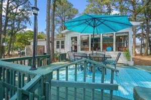 un patio con un tavolo e un ombrellone di Counting Corks - Waterfront, Pet friendly, private dock! a Eastville