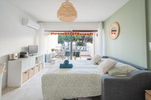 a bedroom with a bed and a living room at Le Cormoran Air-Climatisé-Parking-Vue Marina-Plage in Le Grau-du-Roi