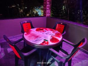 a table and chairs in a room with a pink table at Amruth Homestay Honavar room 2 in Honāvar