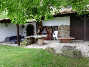 een achtertuinterras met een stenen tafel en een bank bij Statek u Badyho in Dolní Třebonín