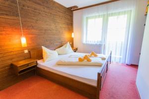 a bedroom with a large bed with a wooden wall at Huberhof 4 by Alpenidyll Apartments in Rohrmoos
