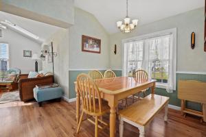 a dining room with a wooden table and chairs at Daisey Cottage - Pet friendly with fenced yard! in Black Point Landing