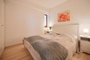 ein weißes Schlafzimmer mit einem Bett und einem Fenster in der Unterkunft Seerose Jutta in Kellenhusen