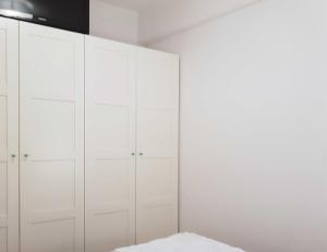 Schlafzimmer mit weißen Schränken und einem Bett in der Unterkunft Seerose Jutta in Kellenhusen