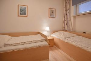 ein Schlafzimmer mit zwei Einzelbetten und einem Fenster in der Unterkunft Seerose Jutta in Kellenhusen + 3 Fotos