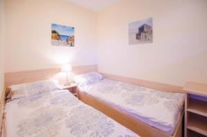 2 Betten in einem Zimmer mit 2 Bildern an der Wand in der Unterkunft Seerose Koki in Kellenhusen
