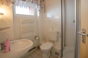 ein Badezimmer mit Toilette, Waschbecken und Dusche in der Unterkunft Seerose Koki in Kellenhusen