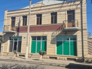 a building with green doors on a street at Uyut Hostel in Ganja