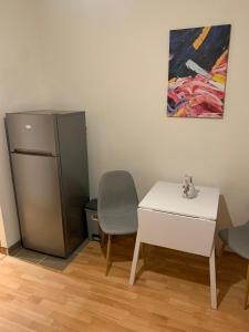 a kitchen with a refrigerator and a table and a chair at Your home 10 with parking in Košice
