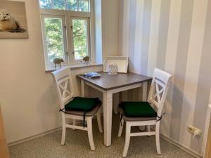 a small table with two chairs and a window at Amselnest in Wyk auf Föhr +6 photos