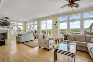 a living room with a couch and chairs and a fireplace at Diving Duck - Waterfront home w Hot tub & Boat dock & King Bed in Greenbackville