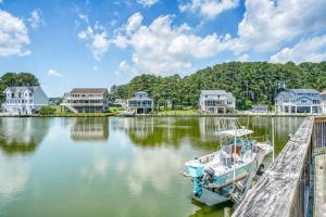 a boat docked at a dock in a lake with houses at Diving Duck - Waterfront home w Hot tub & Boat dock & King Bed in Greenbackville