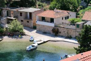 a small boat in the water next to a house at Apartmani Ferri 1 in Vrbanj