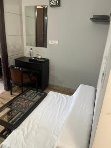 une chambre avec un lit, un bureau et un miroir dans l'établissement Eraya Boutique stays, à Chhatikara