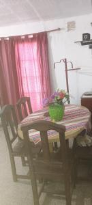 a wooden table with chairs and a bowl of flowers on it at Casa de la Nona in Cordoba