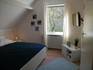 a bedroom with a bed and a window at Ferienhaus 2004 in Tossens in Tossenserdeich
