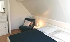 a small bedroom with a bed and a chair at Ferienhaus 2004 in Tossens in Tossenserdeich