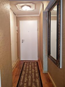 a hallway with a white door with a welcome mat at Carrera Grande Apartment in Piran
