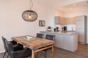 a kitchen and dining room with a wooden table and chairs at Strand Residenz Amrum Strandhaus 6 in Wittdün