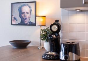 a clock sitting on top of a counter with a coffee maker at Strand Residenz Amrum Strandhaus 6 in Wittdün