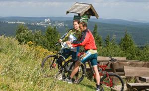 two people riding bikes on a grassy hill at Ferienhaus Nr 3 Sporthotel Oberhof in Oberhof +6 photos