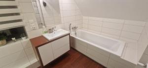 a white bathroom with a tub and a sink at Dom Pod Brzozą in Augustów +39 photos