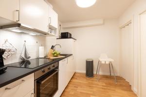 a kitchen with white cabinets and a black counter top at Deich-Ferienhaus 65 qm Königsberger Allee 38 APPARTO Grömitz in Grömitz +17 photos