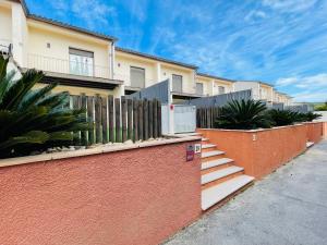 eine Reihe von Häusern mit einem Zaun und einer Treppe in der Unterkunft Sa Tina - Casa con encanto en la Costa Brava L'Estartit in Torroella de Montgrí
