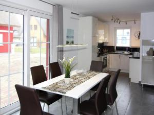 a kitchen and dining room with a white table and chairs at Ferienhaus Lotsenhaus am Breetzer Bodden in Vieregge