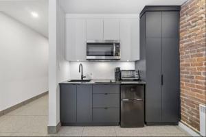 une cuisine avec un évier et un micro-ondes dans l'établissement Initial / Suite trésor / Centre-Ville de Québec, à Québec 22 autres photos