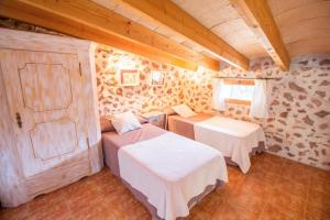 una camera con due letti e una finestra e soffitti in legno di Cas Mostatxet-Wonderful villa with pool a Ballerics Altre 25 foto