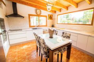 una cucina con tavolo da pranzo e sedie di Cas Mostatxet-Wonderful villa with pool a Ballerics