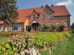 プラウ・アム・ゼーにあるFerienwohnung, Plau am Seeの花の庭園のある大きなレンガ造りの家