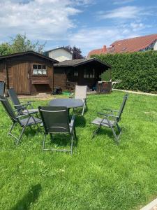 a group of chairs and a table in the grass at Haus Ostwind - Wohnung 3 in Dahme